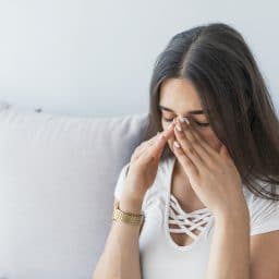 Woman experiencing sinus pressure and allergy symptoms.