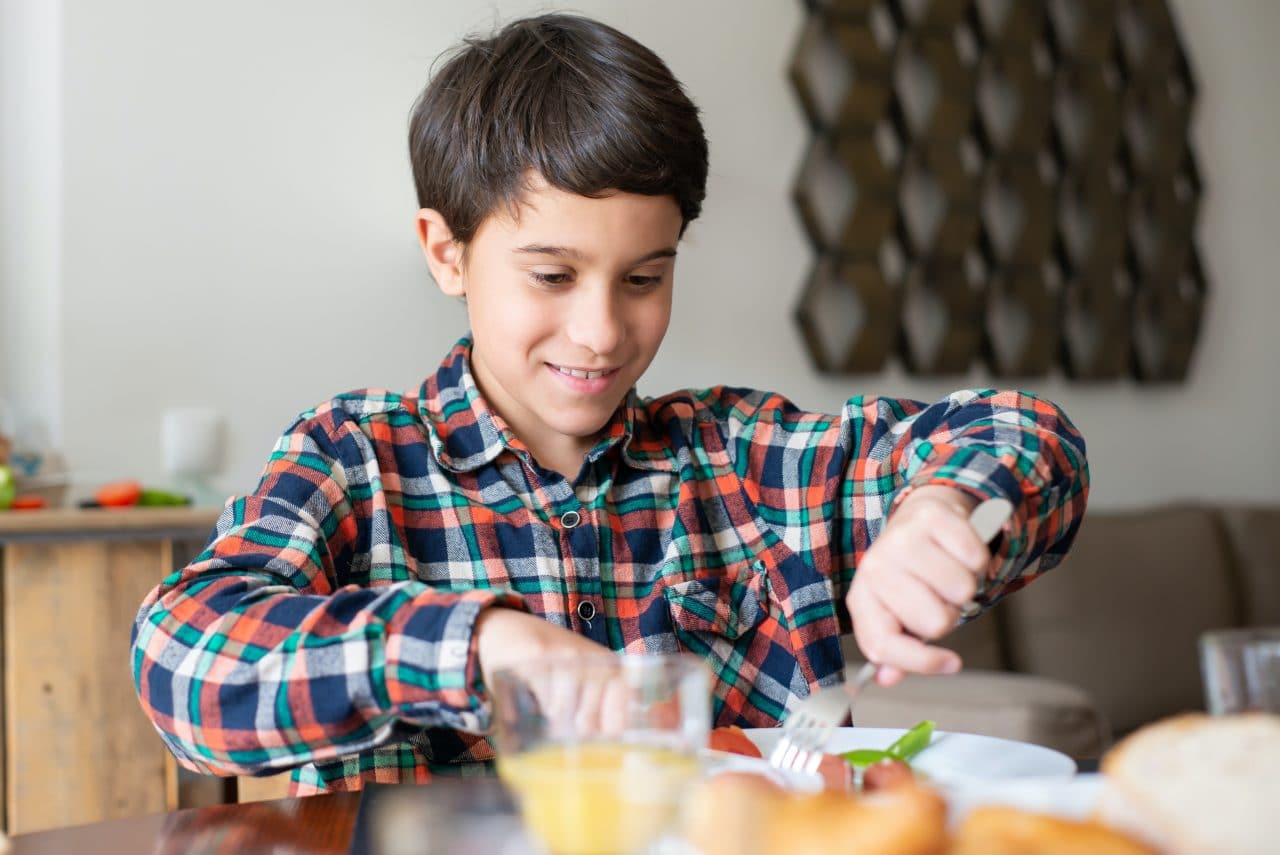 Young boy eating a meal at home.