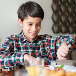 Young boy eating a meal at home.