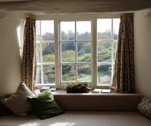 Shot of an open window with curtains inside of a house.