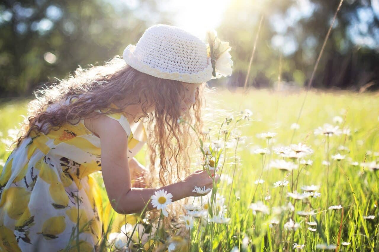 Little girl playing in the wild flowers.