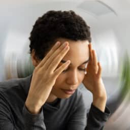 A woman experiencing a dizzy spell with a blurry, spinning background image