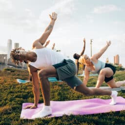 Three people doing yoga outdoors