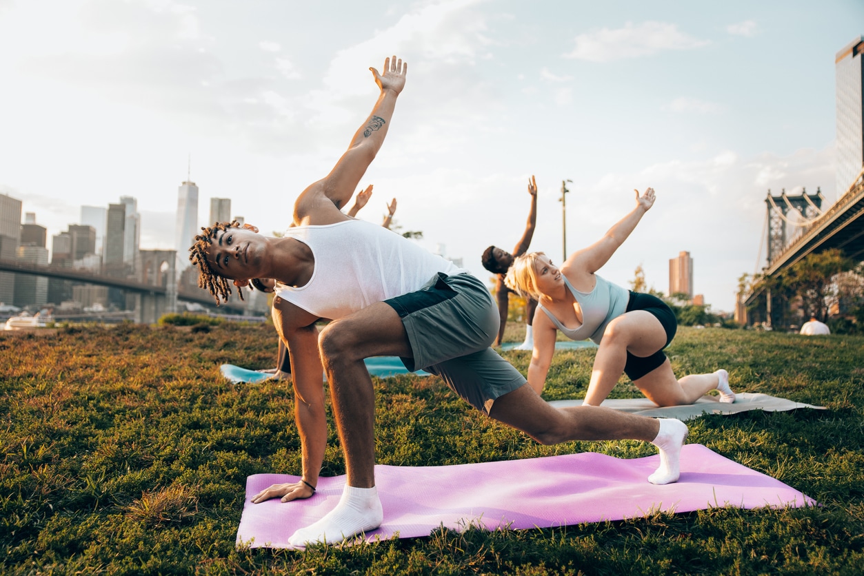 Three people doing yoga outdoors