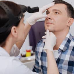 ENT specialist examining a man's nose