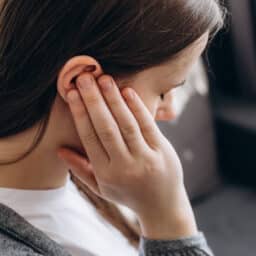 Woman holds ear
