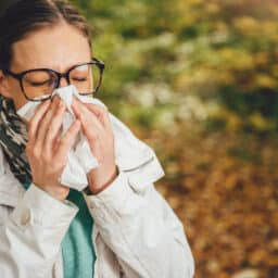 Woman sneezing on her hike.