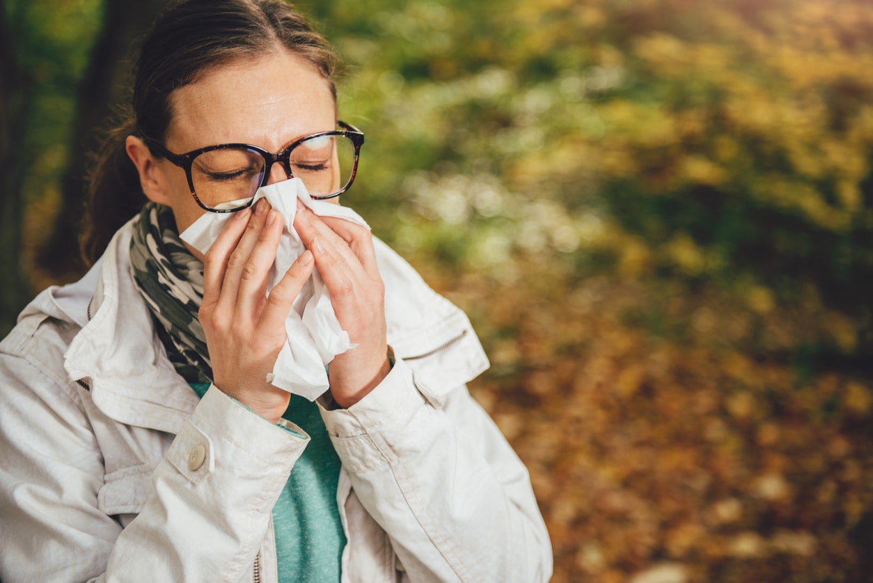 Woman sneezing on her hike.