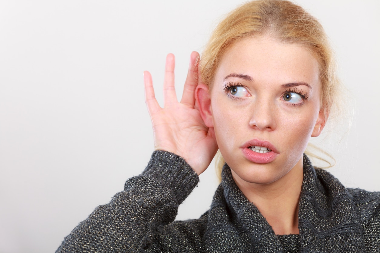 Woman put hand to ear for better hearing.